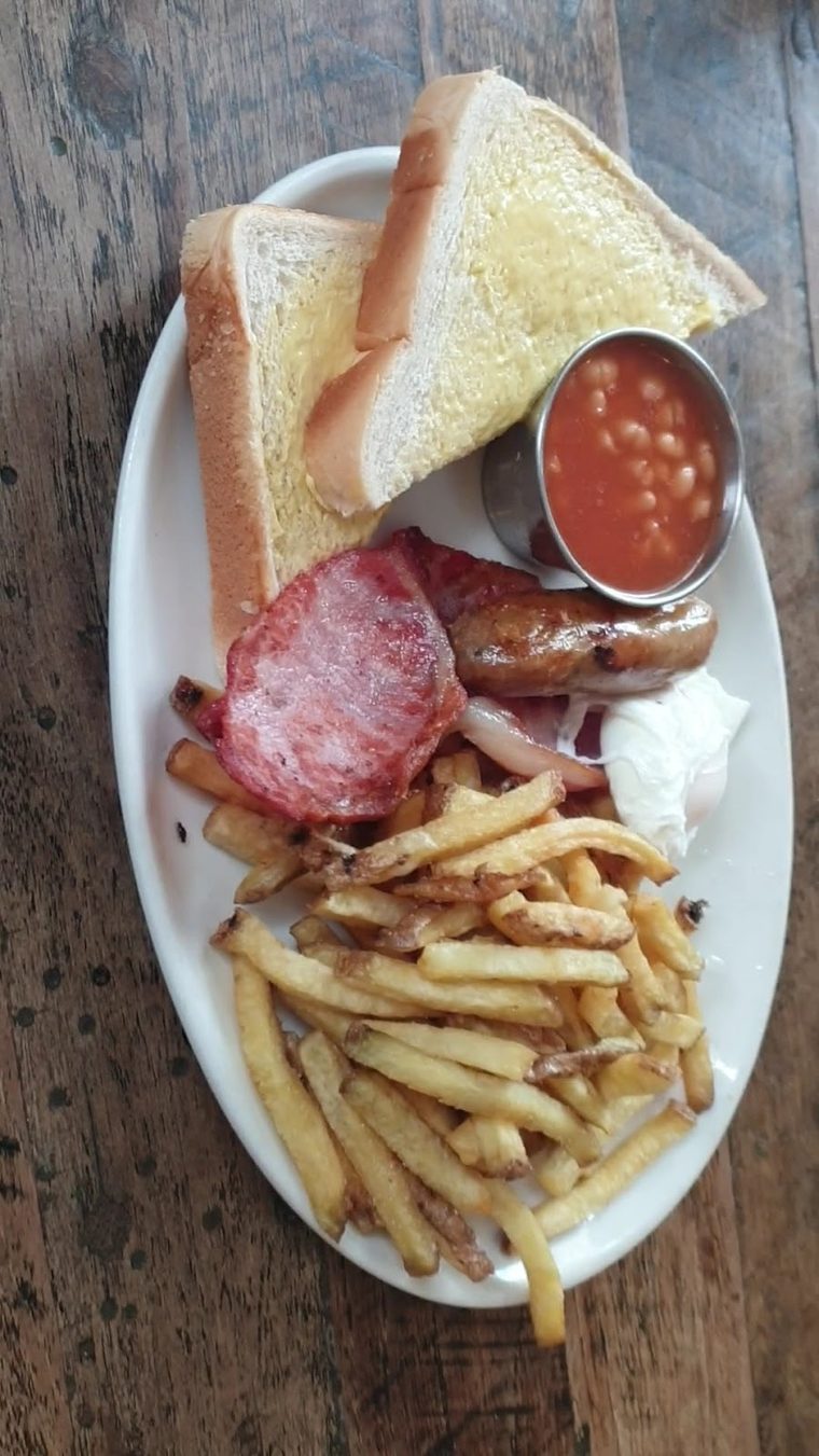 Full English breakfast with beans served in a pot and buttered toast