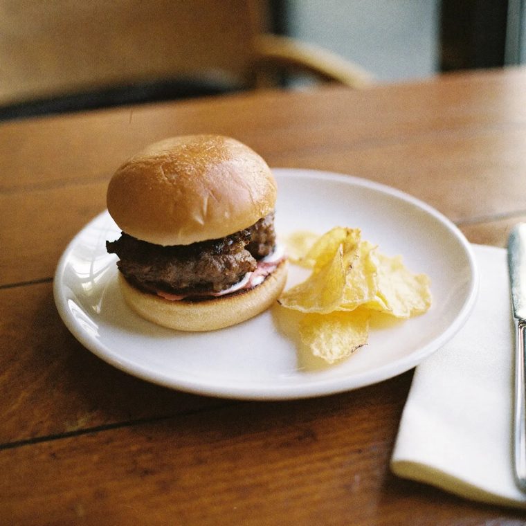 A burger and chips on a white plate